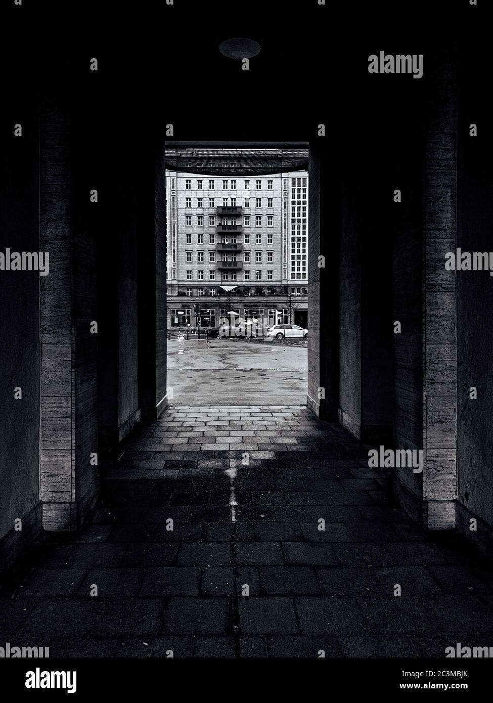 Photo verticale en niveaux de gris d'une rue et des bâtiments capturés d'un tunnel Banque D'Images