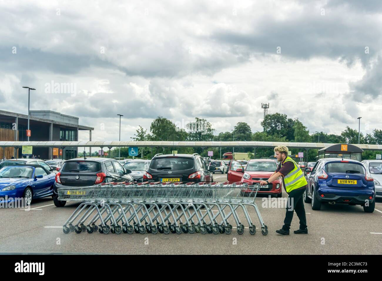 Récupération des chariots dans un parking de supermarché. Banque D'Images