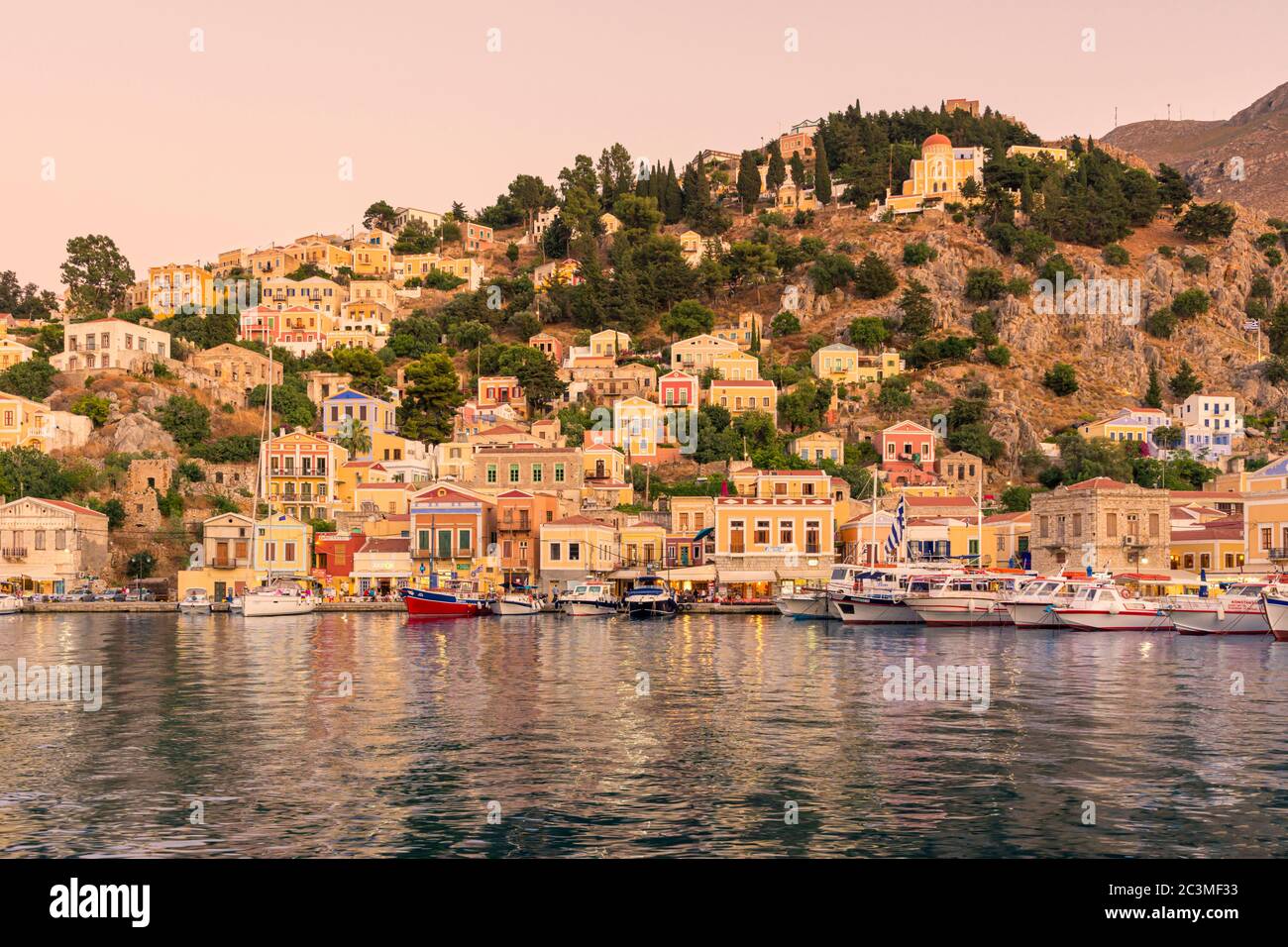 Coucher de soleil sur les manoirs côté pot de Gialos, Symi Island, Dodécanèse, Grèce Banque D'Images