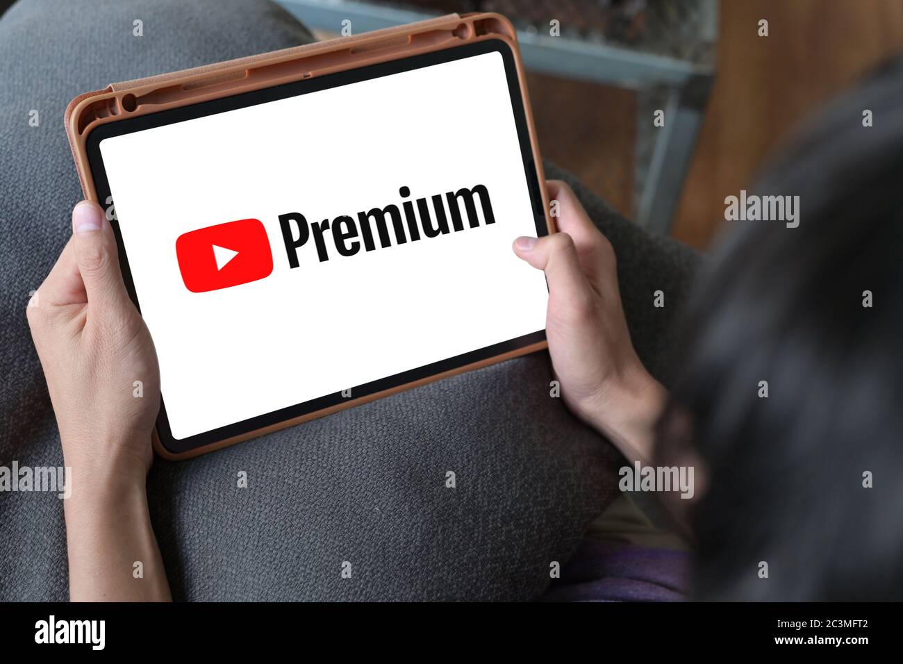 Homme regardant YouTube Premium sur iPad, avec YouTube Premium, profitez d'un accès sans publicité, de téléchargements et de la lecture en arrière-plan sur YouTube et YouTube Music by Banque D'Images