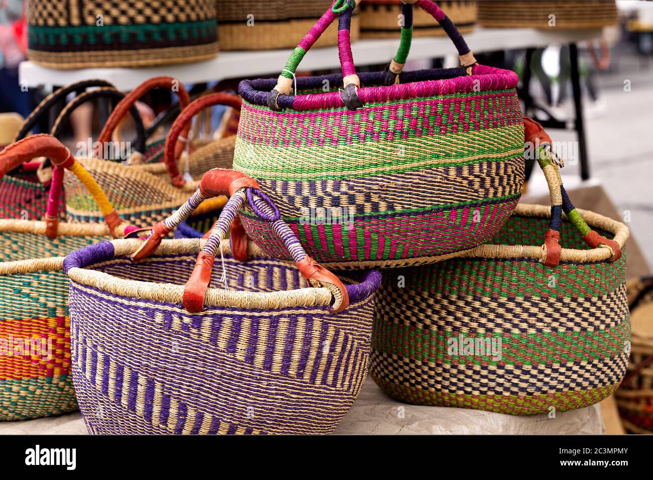 Grands paniers ouest-africains avec poignées en cuir exposés sur un marché local extérieur Banque D'Images