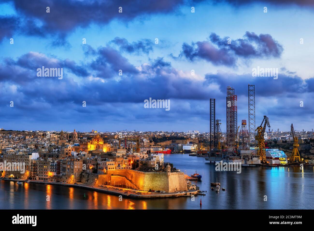 Ville de Senglea et chantier naval au crépuscule dans le Grand Port de Malte île dans la mer de Mediterraenan. Banque D'Images