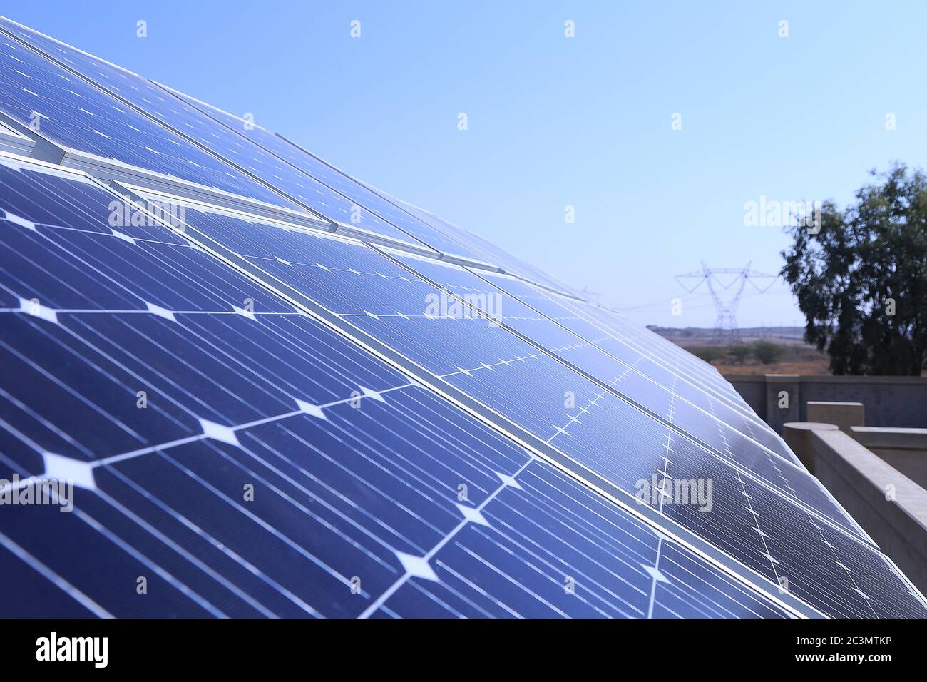Panneaux solaires sur le toit en vue rapprochée, pylône haute tension en arrière-plan Banque D'Images