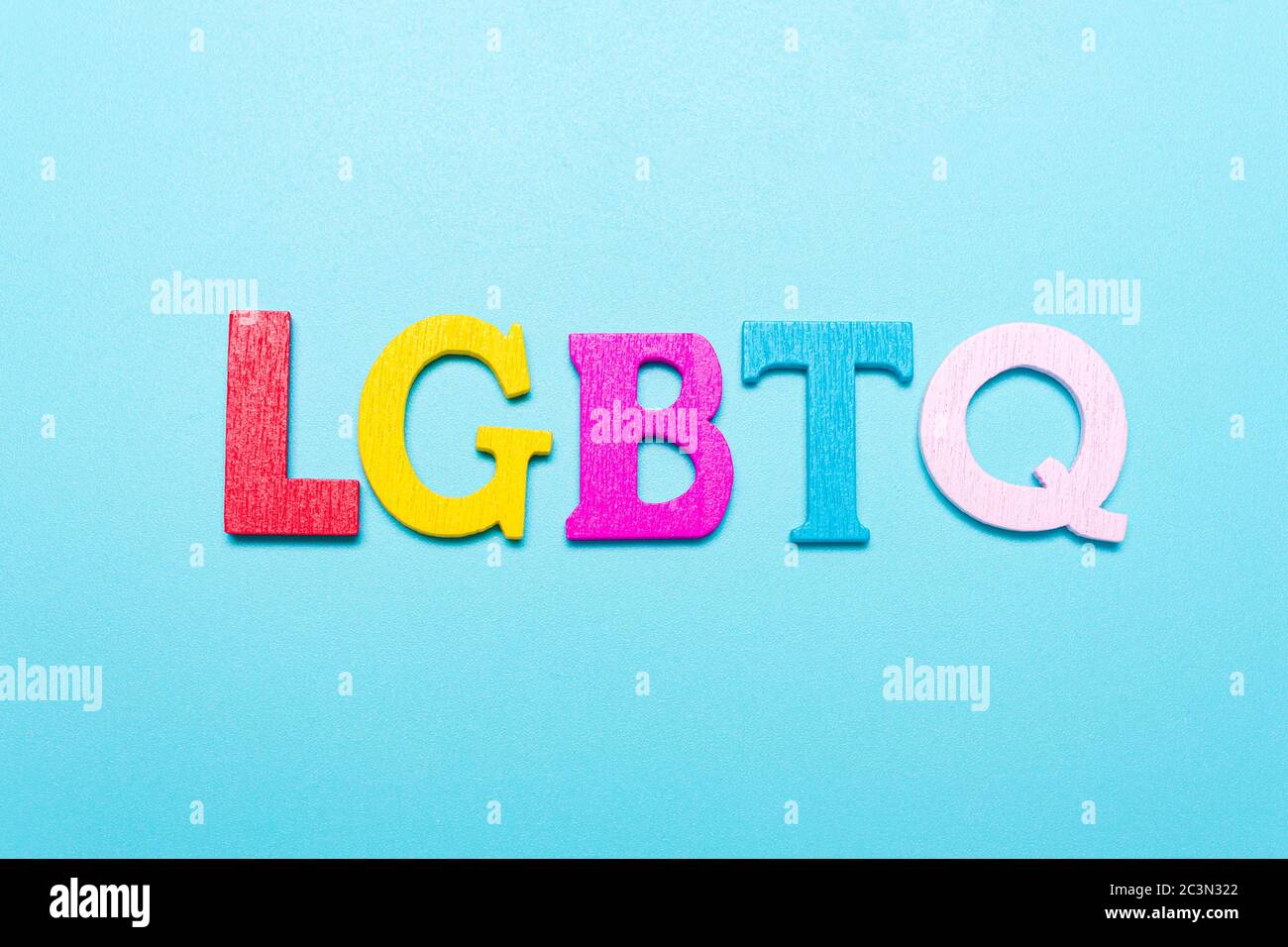 Mot LGBTQ de lettres de couleur arc-en-ciel sur fond bleu Banque D'Images