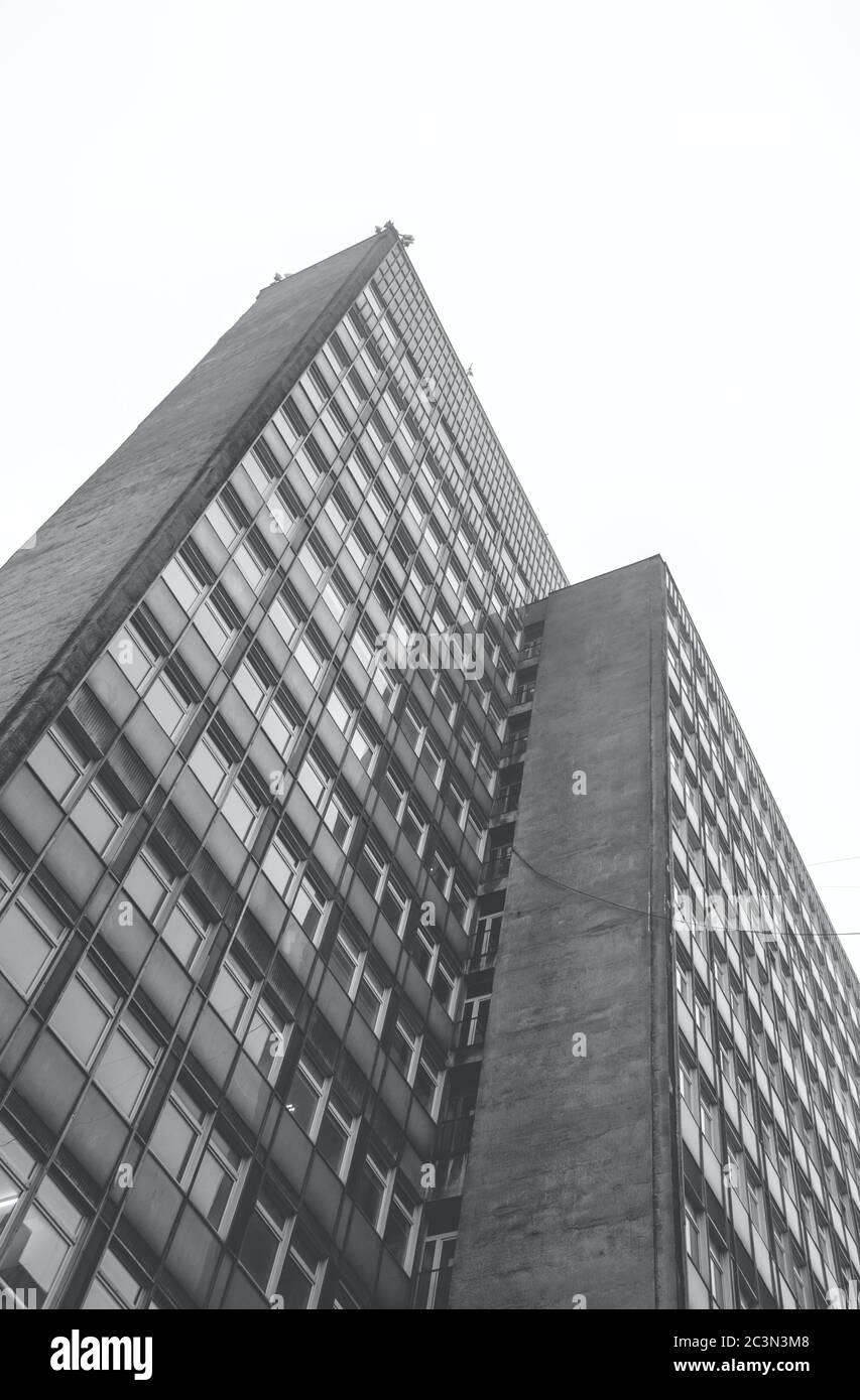 Prise de vue verticale en niveaux de gris à faible angle d'un bâtiment résidentiel à jour Banque D'Images