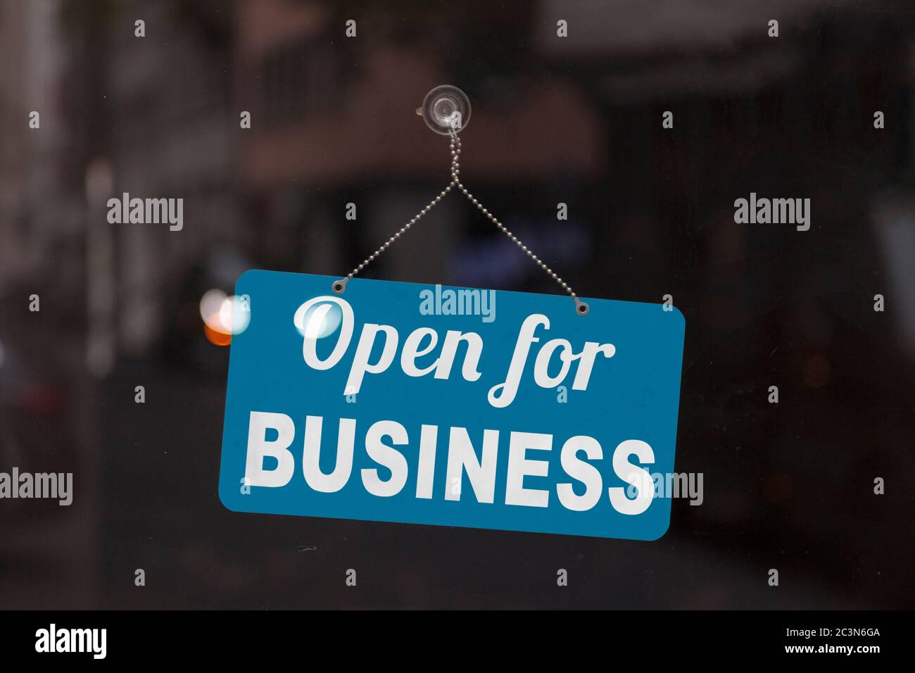 Gros plan sur un panneau bleu ouvert dans la fenêtre d'une boutique affichant le message : Open for Business. Banque D'Images