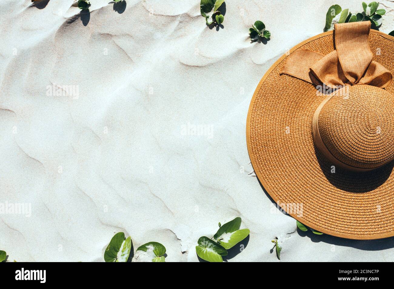 Flat lay, chapeau de paille sur sable blanc, accessoire d'été, vue de dessus, cadre vert sur fond blanc. Photo publicitaire. Copier l'espace, l'espace à coller Banque D'Images