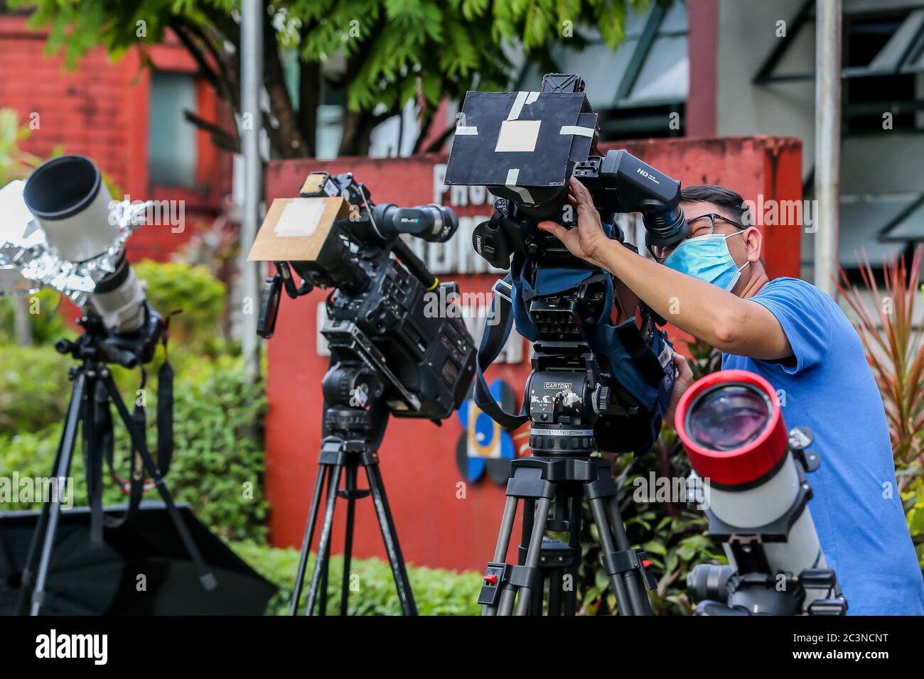 Manille. 21 juin 2020. Un caméraman prend une vidéo de l'éclipse solaire partielle à Manille, aux Philippines, le 21 juin 2020. Crédit: Rouelle Umali/Xinhua/Alay Live News Banque D'Images