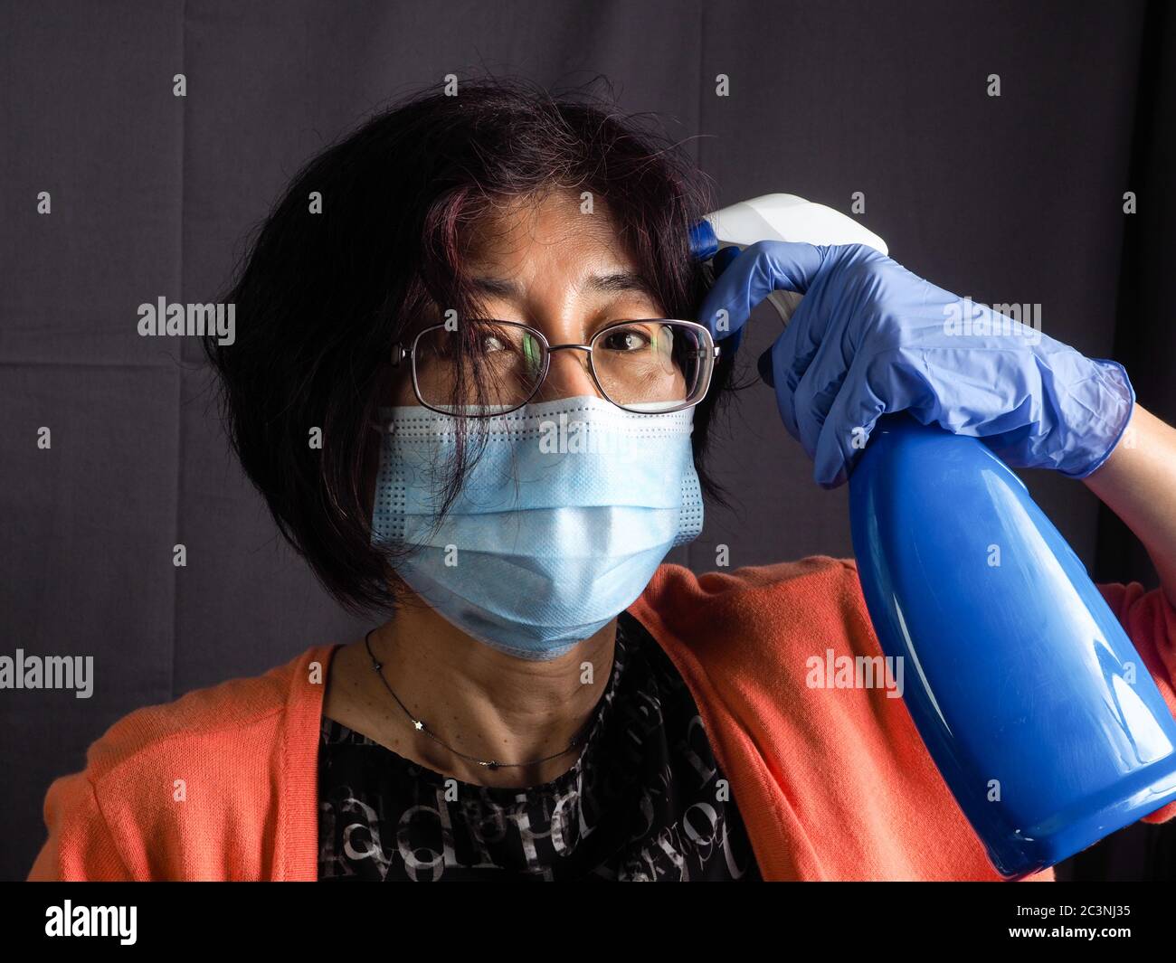 drôle humoristique adulte asiatique 40s 50s femme portant une protection  masque chirurgical, des gants en latex bleu, et des lunettes de soleil  pointant la tête avec saniti bleu Photo Stock - Alamy