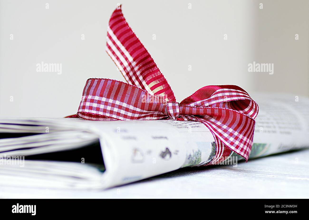 Abonnement à un journal en cadeau avec ruban rouge Photo Stock - Alamy