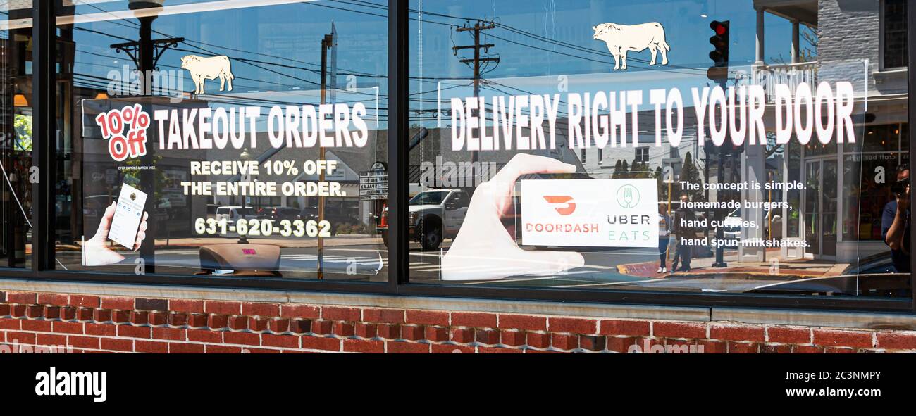 Babylone, New York, Etats-Unis - 13 mai 2020: Livraison par tablier porte disponible pour les commandes à emporter sur les fenêtres d'un restaurant dans le village de Babylone en raison de la Banque D'Images Babylone, New York, Etats-Unis - 13 mai 2020: Livraison par tablier porte disponible pour les commandes à emporter sur les fenêtres d'un restaurant dans le village de Babylone en raison de la Banque D'Images