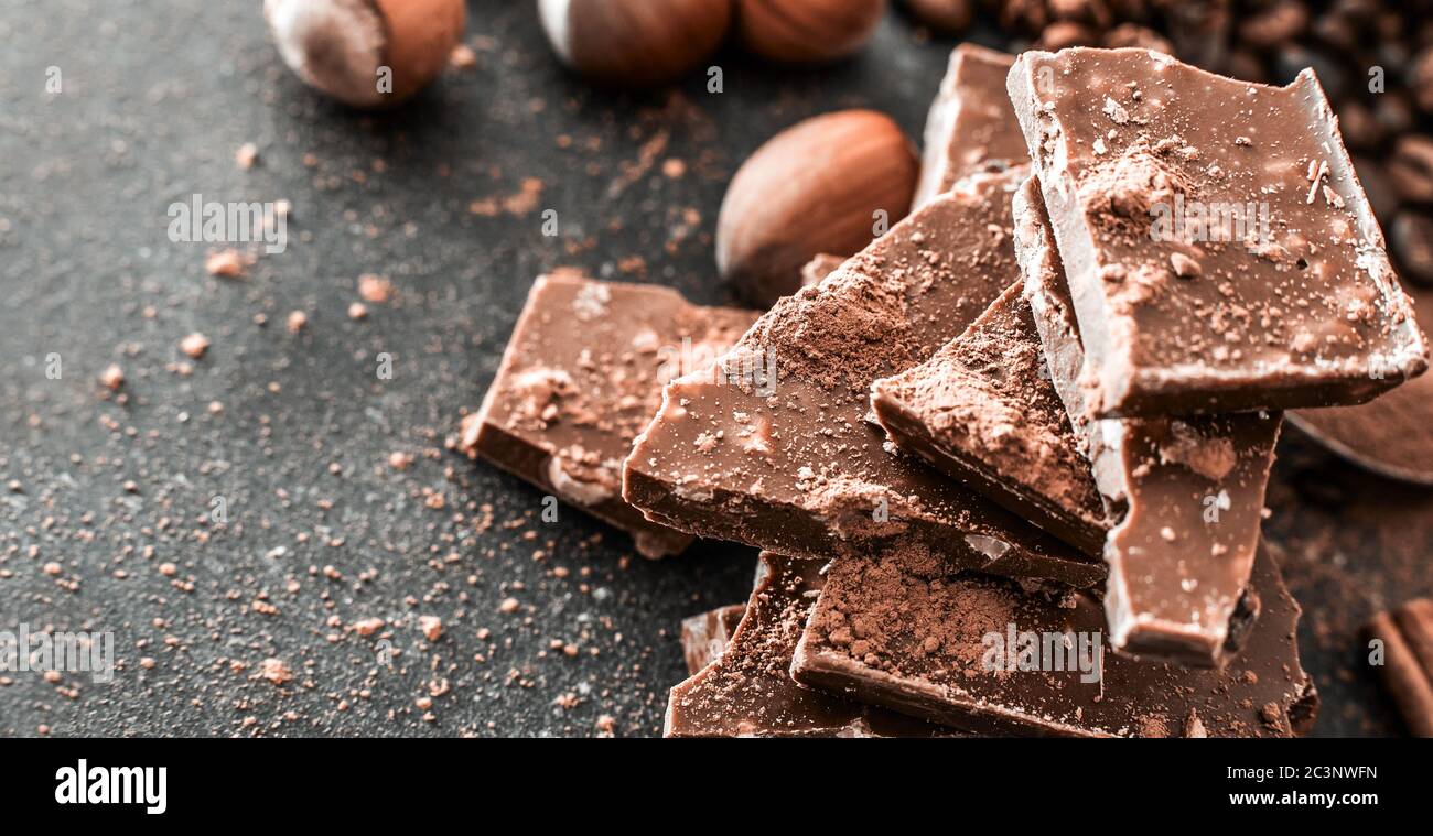 Chocolat et noix sur une table noire avec une surface usée Banque D'Images