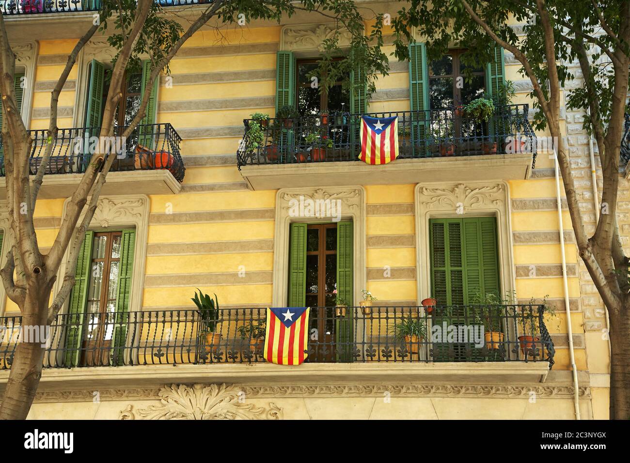 Drapeaux catalans accrochés sur les balcons d'un bâtiment à Barcelone. Banque D'Images