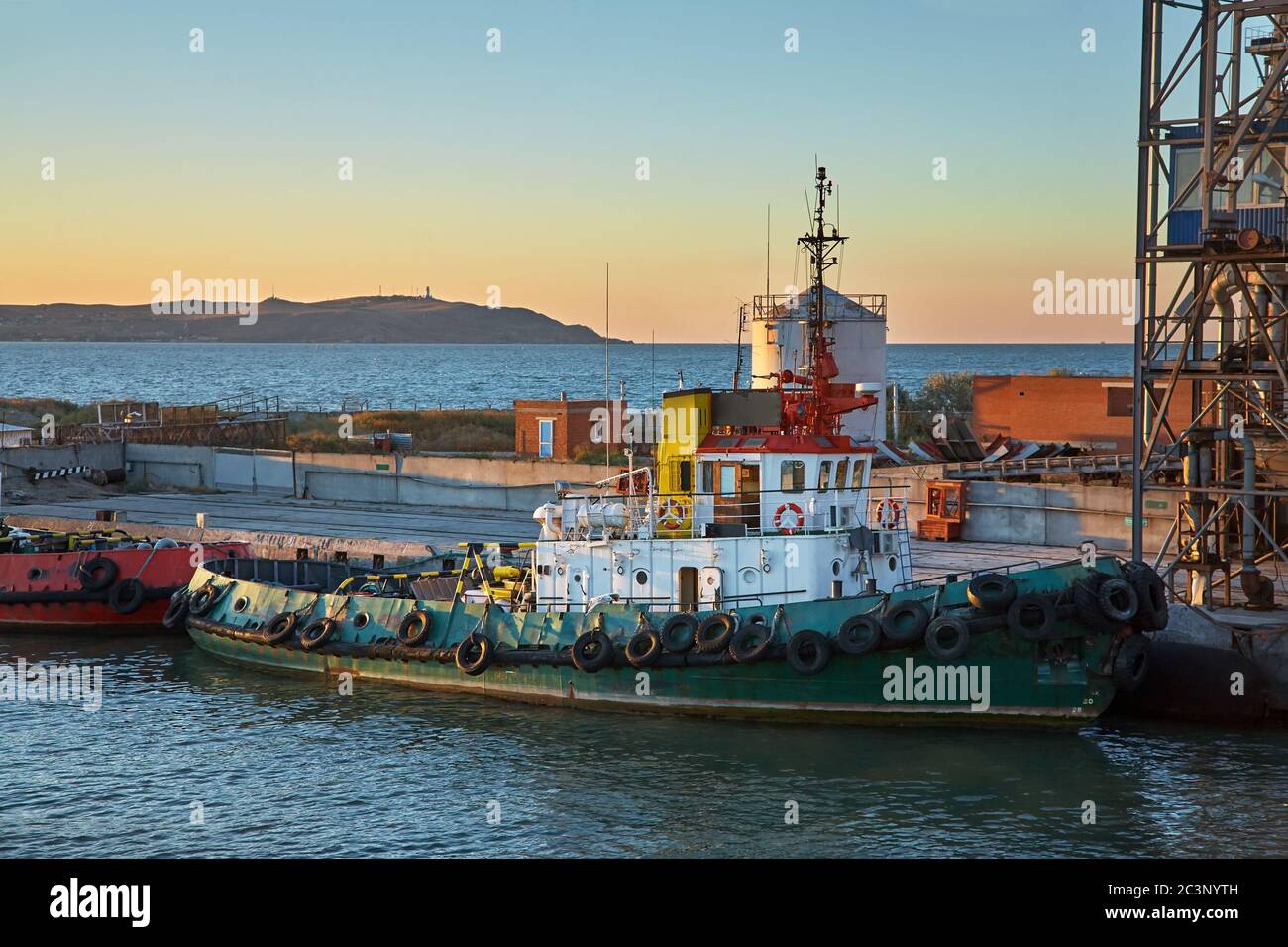 Navires dans un port de cargaison au coucher du soleil. Banque D'Images