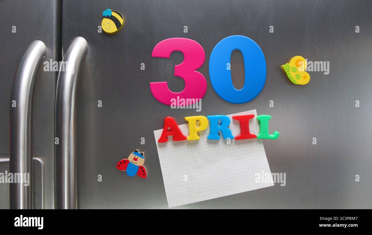 Date du calendrier du 30 avril avec des lettres magnétiques en plastique portant une note de papier graphique sur le réfrigérateur de porte Banque D'Images