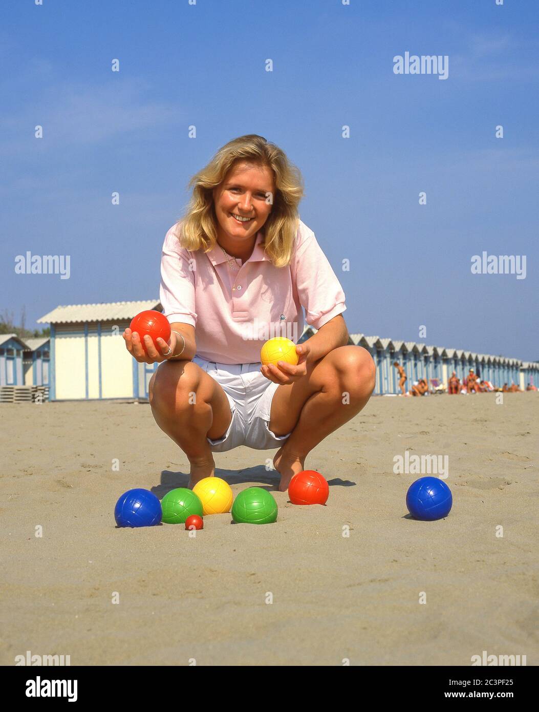 Jeune femme jouant au jeu de boules sur la plage, Lido di Jesolo, province de Venise, région de Vénétie, Italie Banque D'Images