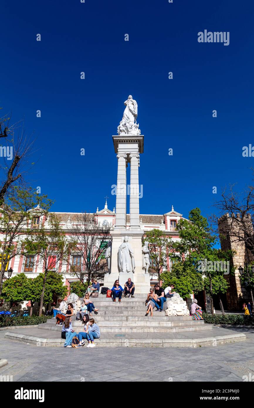 Touristes assis au Monument de l'Immaculée conception à Plaza del Triunfo dans la vieille ville de Séville, Andalousie, Espagne Banque D'Images