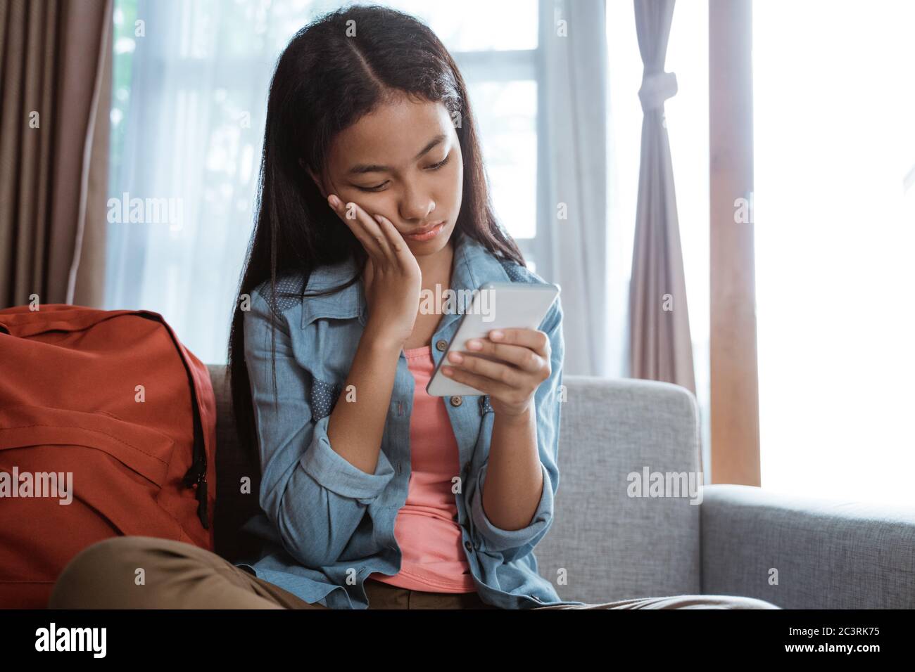 pression des pairs. les jeunes adolescentes asiatiques se sentent déprimant lors de l'utilisation de son téléphone mobile à la maison Banque D'Images