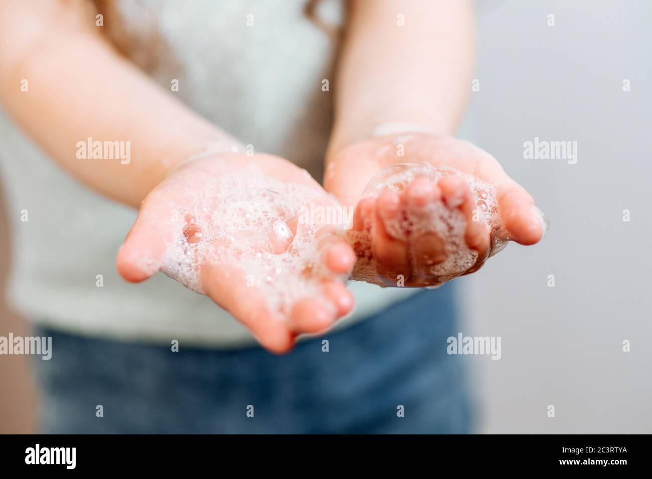 Mains d'enfants en mousse savonneuse. Concept mains propres. Hygiène et santé Banque D'Images