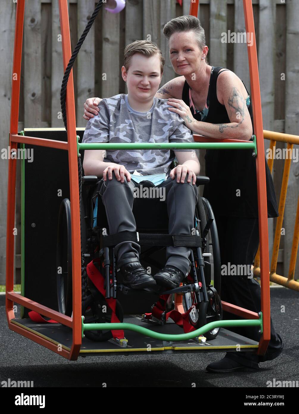 Gregor Marshall aux côtés de sa mère Karen Gregor ayant une promenade sur le balançoire en fauteuil roulant dans la zone de thérapie extérieure au Centre Craighalbert. Des adaptations du coronavirus ont été installées au Scottish Center for Children with Motor déficiences, au Craighalbert Center, à Cumbernauld, alors que l'Écosse continue de lever progressivement les mesures de verrouillage du coronavirus. Banque D'Images