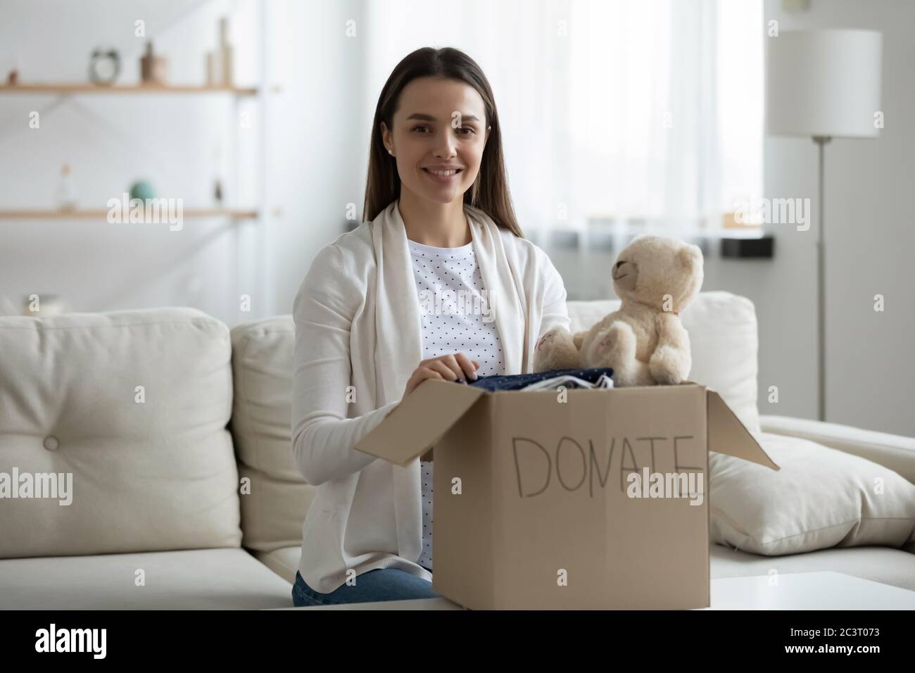 Femme préparer une boîte de don avec de vieux trucs pour la charité Banque D'Images