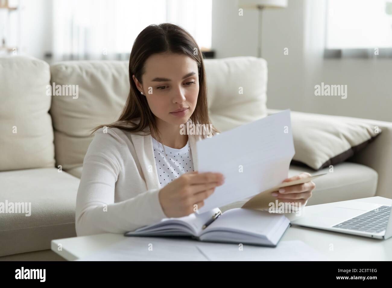 Une femme triste a lu la lettre postale d'un ami se sent frustrée Banque D'Images