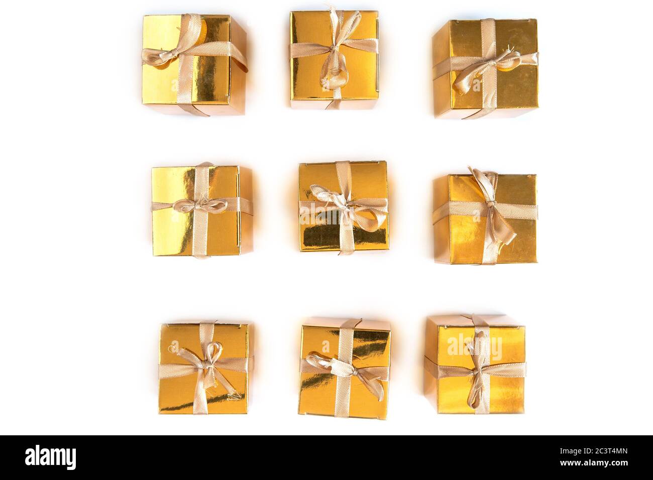 Ensemble de boîtes cadeau ou cadeau en or étincelant dans une rangée avec noeud isolé sur fond blanc, Banque D'Images