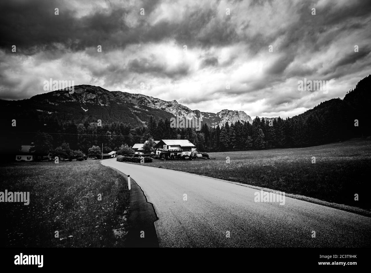 Paysage spectaculaire de montagnes avec route sous ciel nuageux, processus en noir et blanc Banque D'Images