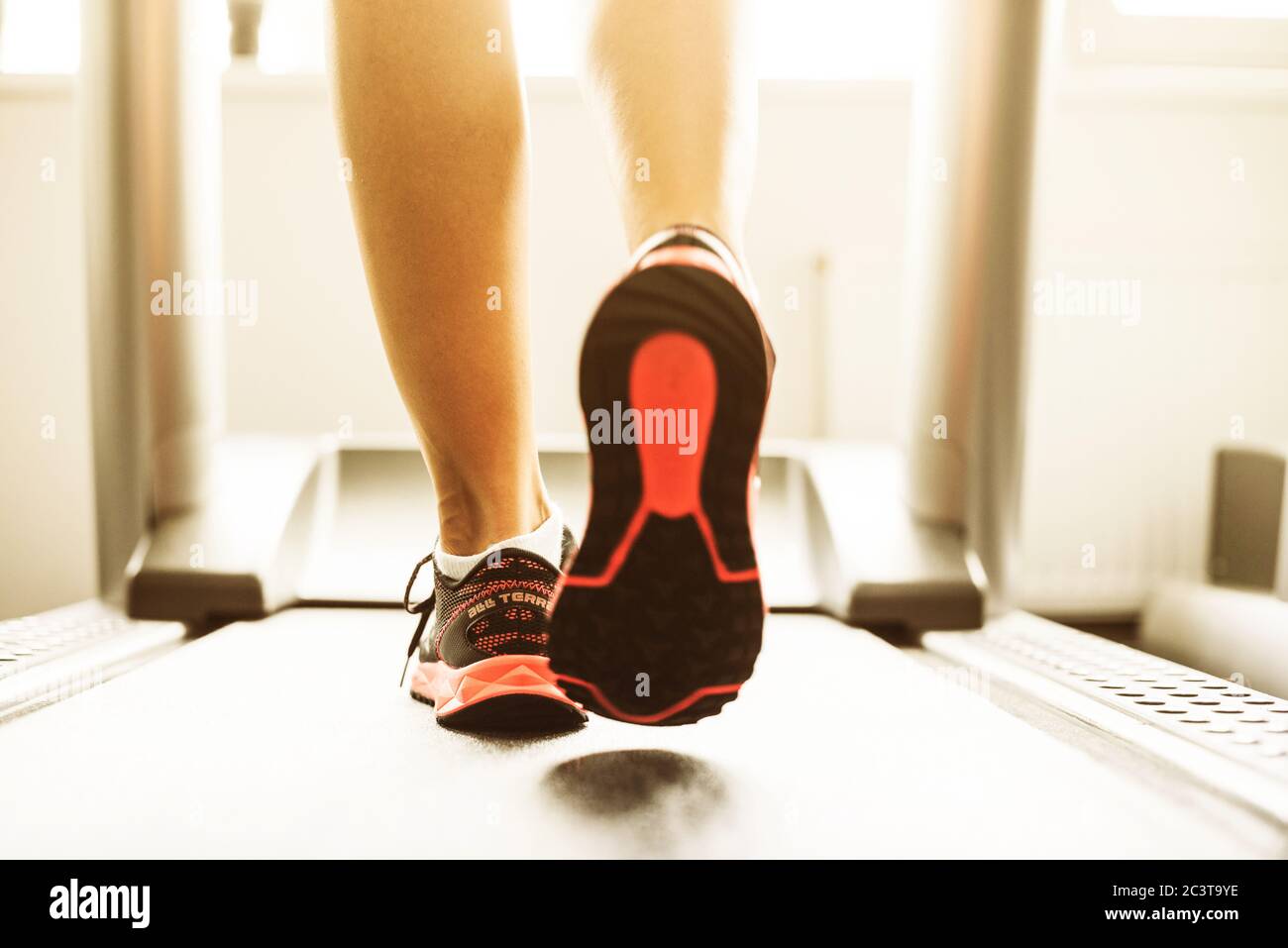 Fitness petite fille d'exécution sur un tapis roulant. Femme avec des jambes musclées in gym Banque D'Images