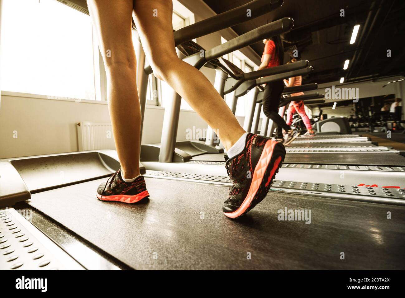 Fitness petite fille d'exécution sur un tapis roulant. Femme avec des jambes musclées in gym Banque D'Images