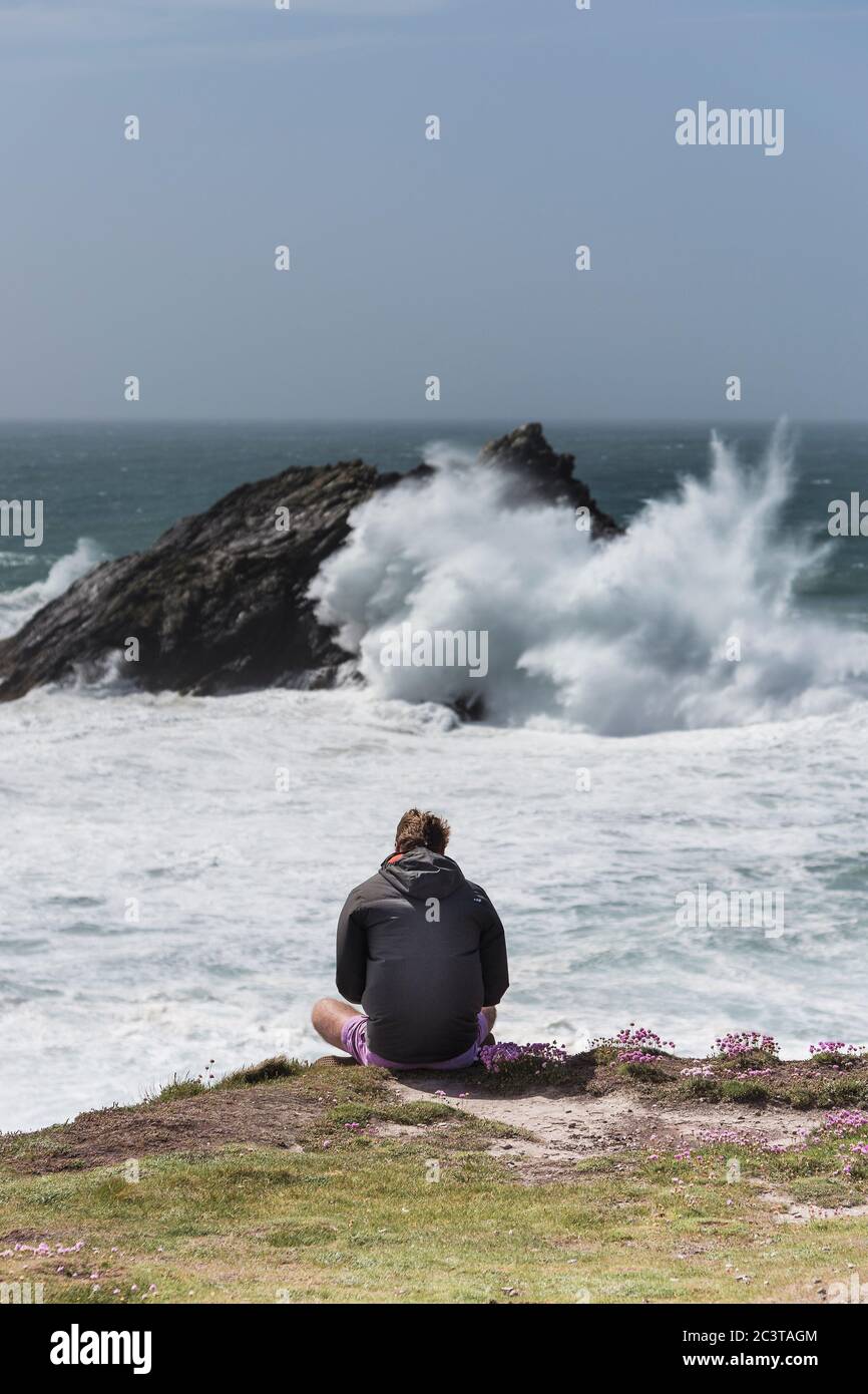 Un touriste appréciant la vue spectaculaire de Pentire point East sur la côte de Newquay dans les Cornouailles. Banque D'Images