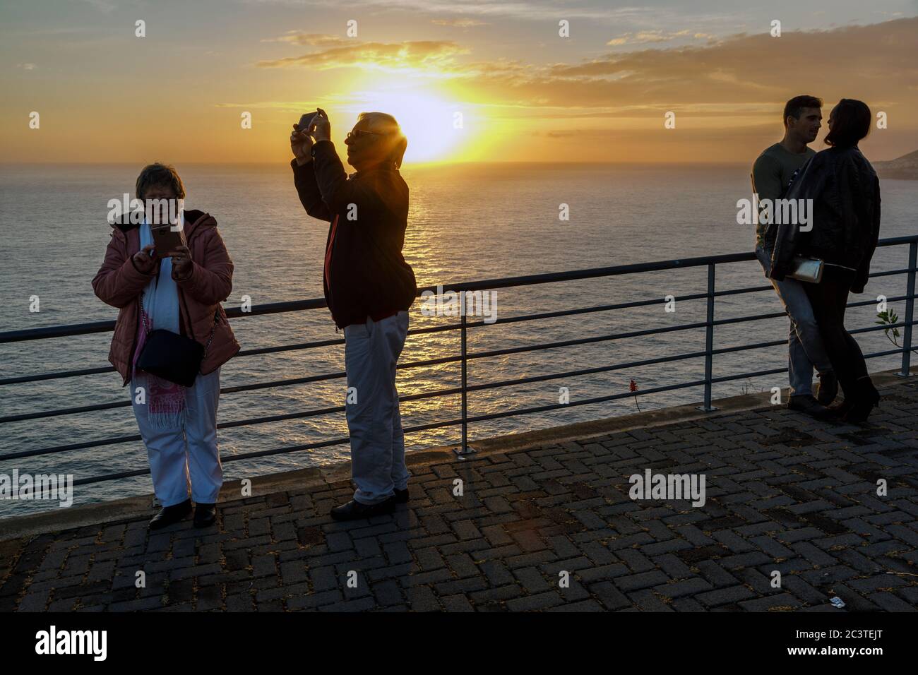 Deux couples, un jeune couple et un couple d'âge moyen, à la Cristo Rei, au coucher du soleil vue Garajau, Madère Banque D'Images