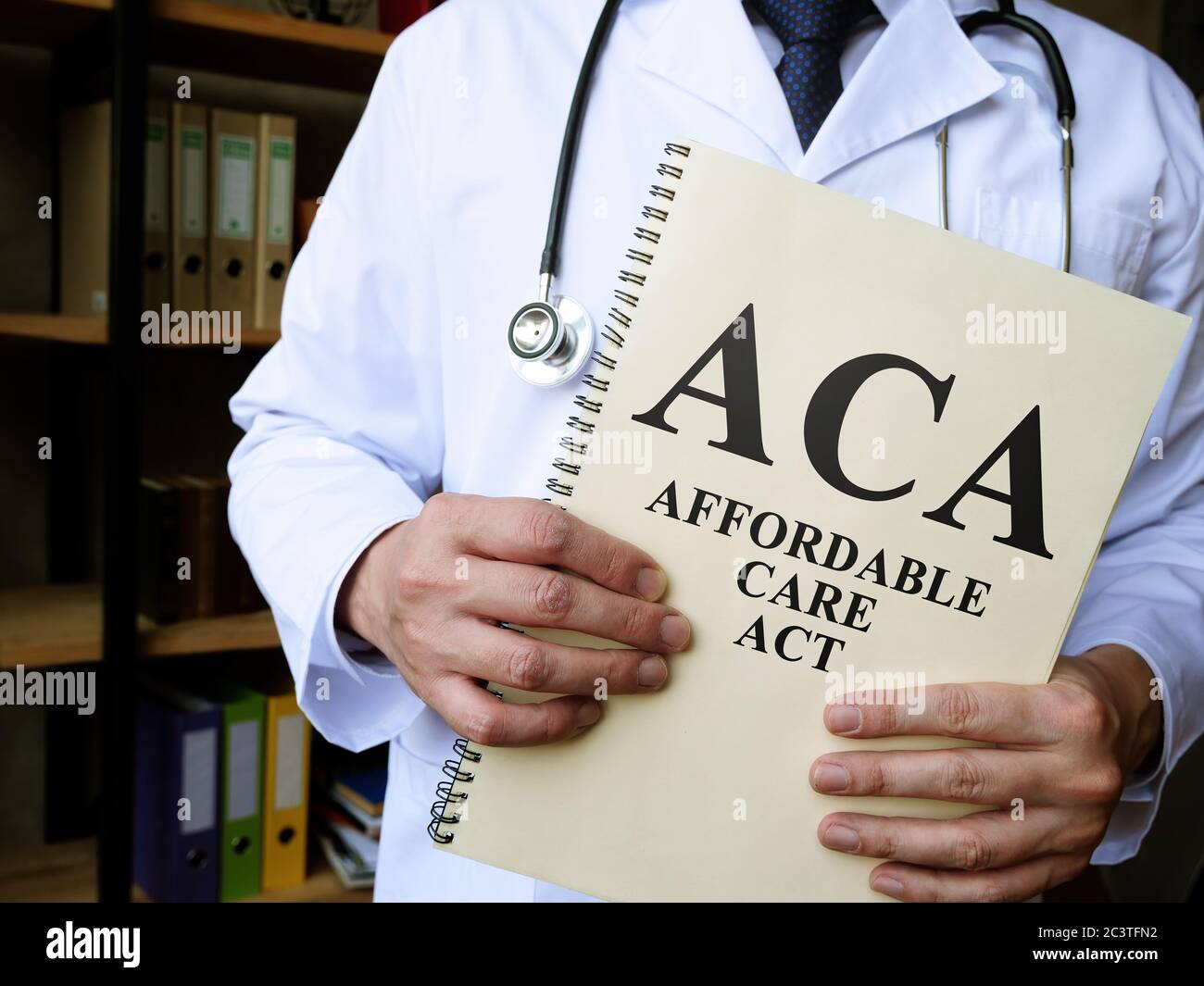 Le médecin détient un livre Affordable Care Act ACA. Banque D'Images