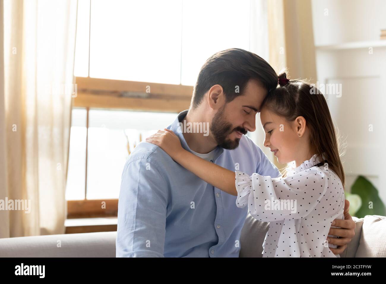 Père aimant et petite fille touchant les fronts, profitant de moments tendres Banque D'Images