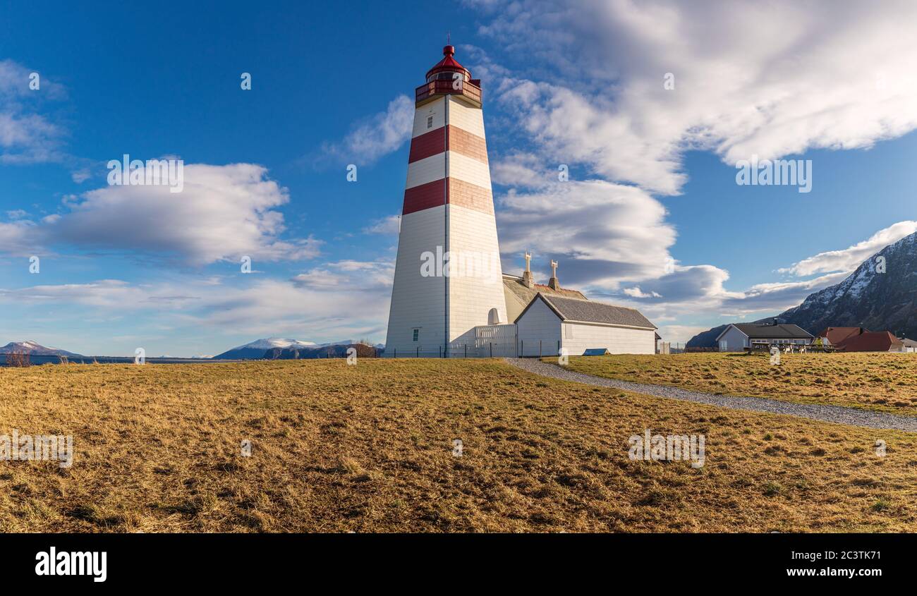 Célèbre phare d'Alnes, Norvège, en fin d'après-midi, chaud, au printemps. Scène tranquille avec une grande tour, un ciel bleu et des nuages lentement mobiles Banque D'Images