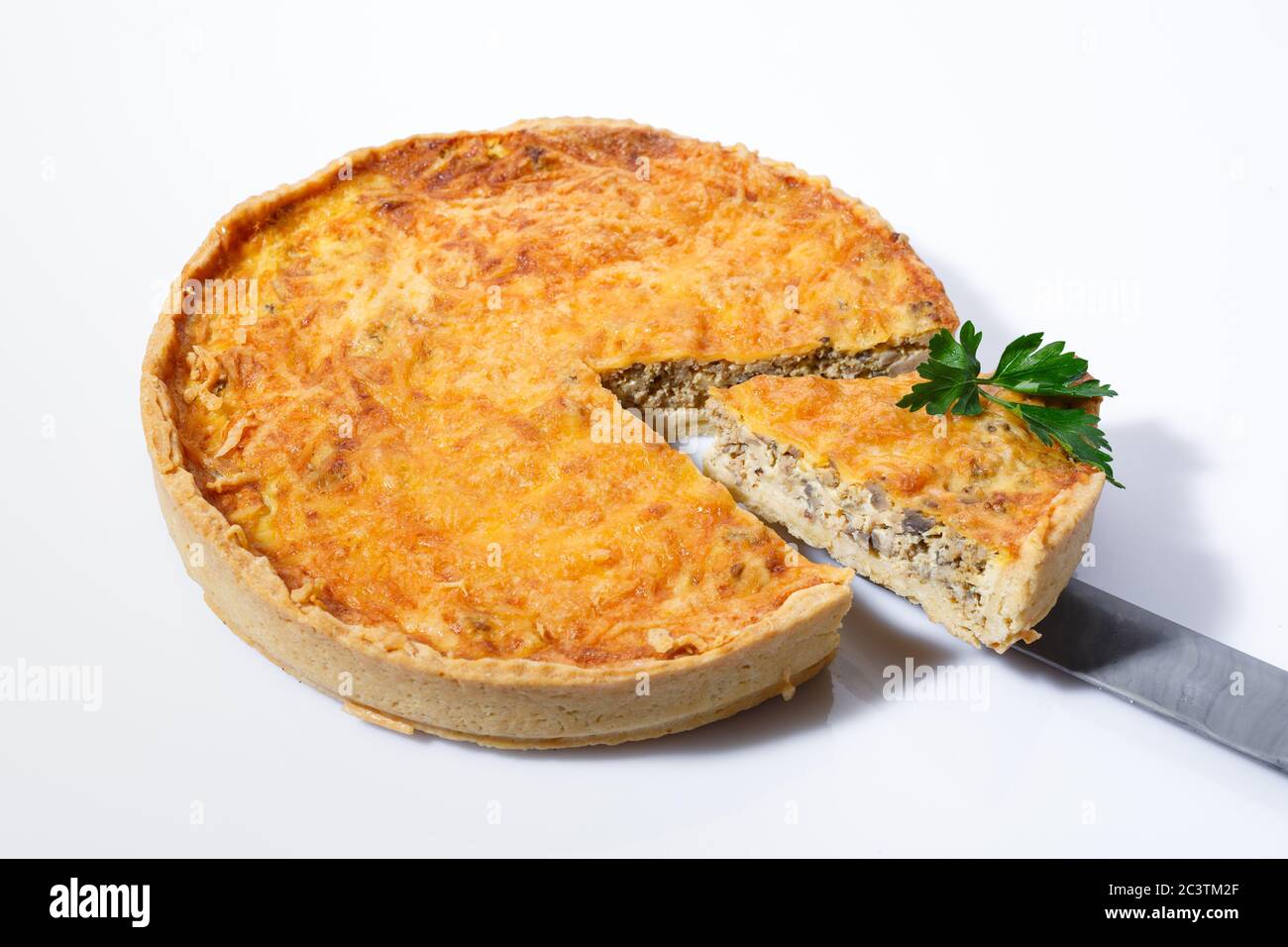 Tarte délicieuse avec viande, champignons, fromage et herbes sur fond blanc. Banque D'Images