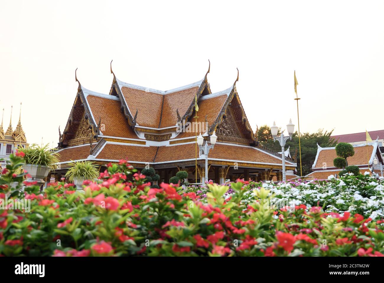 Temple Wat Ratchanatdaram avec fleurs en premier plan à Bangkok, Thaïlande. Banque D'Images
