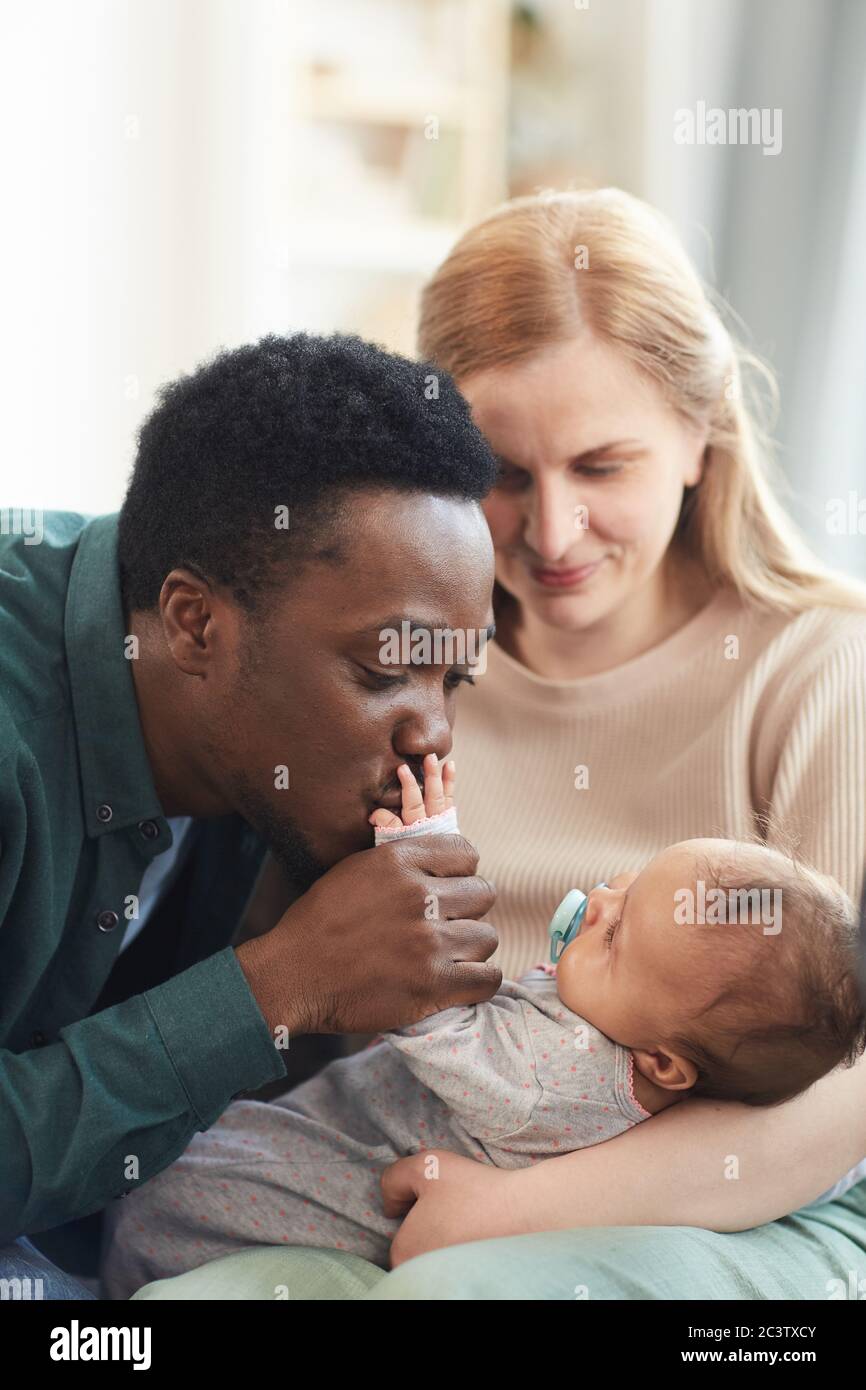 Portrait Vertical Du Jeune Couple Interracial Se Concentre Sur L Homme Afro Americain Embrassant La Petite Main De Bebe Mixte Photo Stock Alamy
