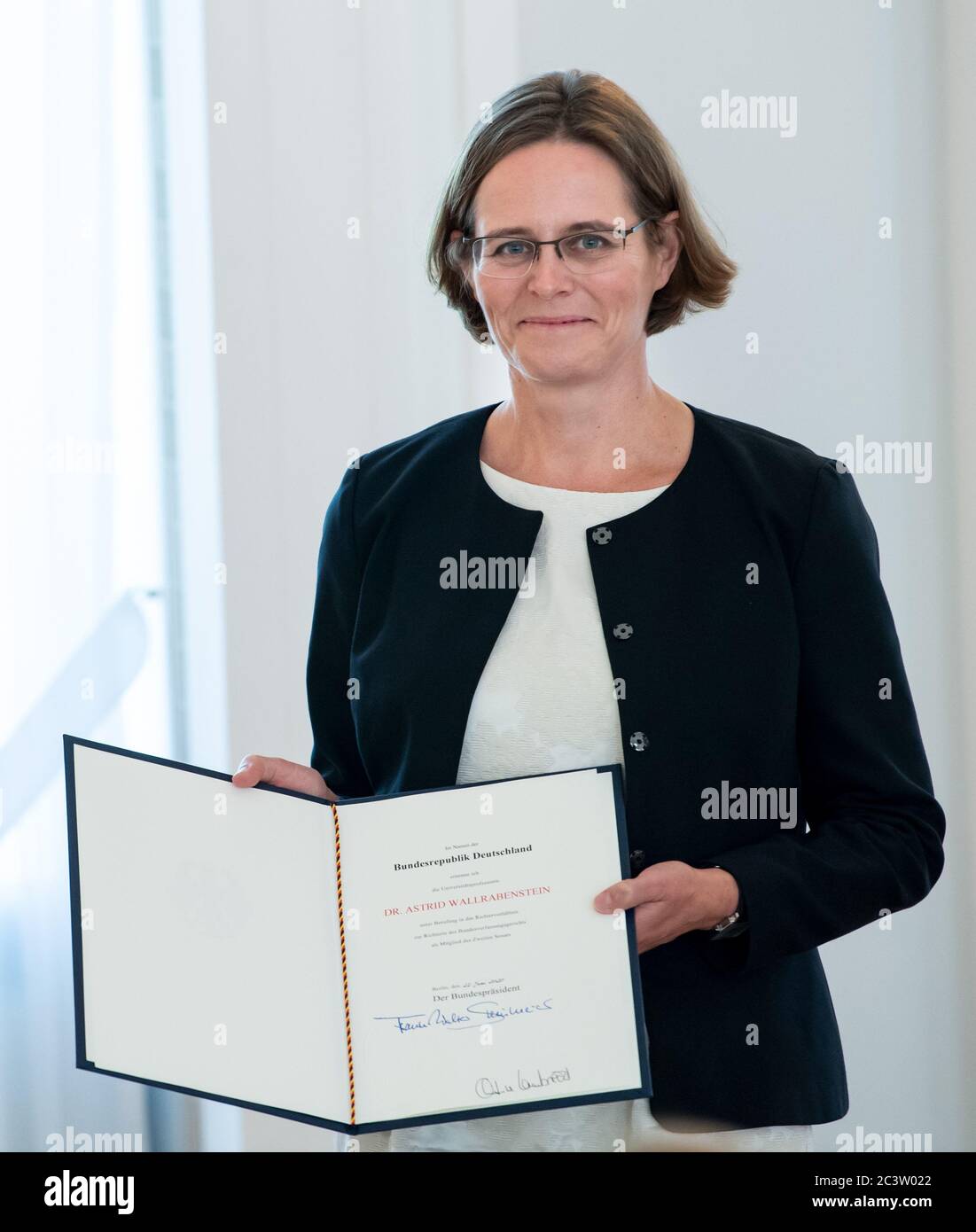 22 juin 2020, Berlin : Astrid Walrabenstein détient le certificat de nomination en sa main à la suite de sa nomination par le Président fédéral Steinmeier au poste de juge à la Cour constitutionnelle fédérale. L'ancien Président de la Cour constitutionnelle fédérale, Voßkuhle, s'était retiré de ses fonctions par rotation après douze ans à Karlsruhe, dont dix étaient à la présidence. Sur la suggestion des Verts, Wallrabenstein, professeur de droit à Francfort, prendra la relève du deuxième Sénat qui deviendra vacant. Photo: Bernd von Jutrczenka/dpa Pool/d Banque D'Images