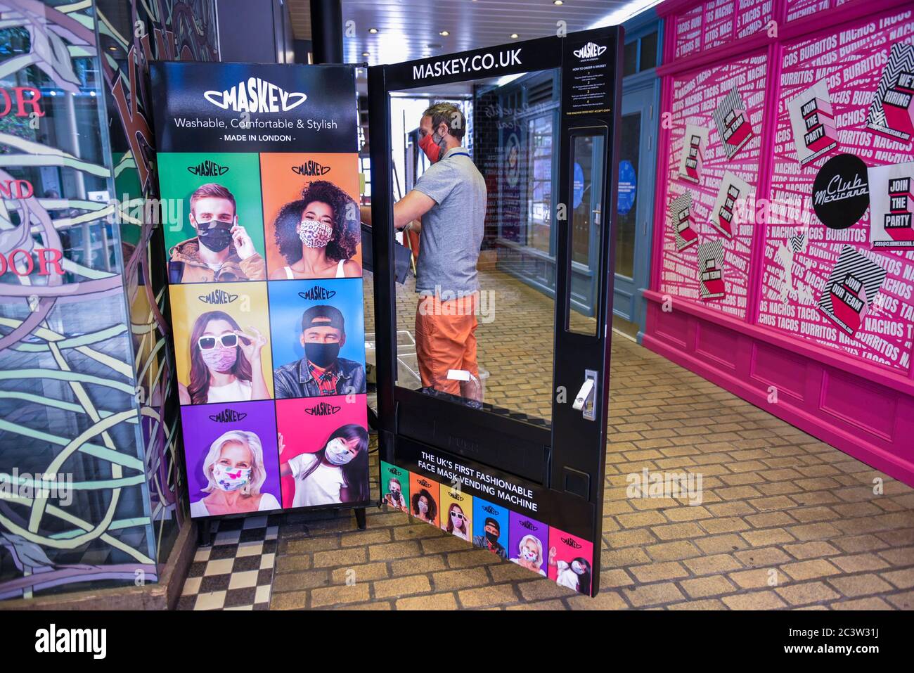 Londres, Royaume-Uni. 22 juin 2020. Un membre du personnel charge un distributeur automatique à Carnaby Street vendant des masques de visage au public par la société londonienne Maskey. Créée par l'expéditeur Adam Freeman pour répondre à la demande de masques abordables fabriqués au Royaume-Uni pendant la pandémie de coronavirus en cours, la nouvelle entreprise installe les premiers distributeurs automatiques de masques faciaux tendance du Royaume-Uni dans les environs de Londres, avec des projets d'expansion. 10 % des bénéfices de chaque vente de facemask sont donnés à un organisme de bienfaisance soutenant le NHS. Credit: Stephen Chung / Alay Live News Banque D'Images