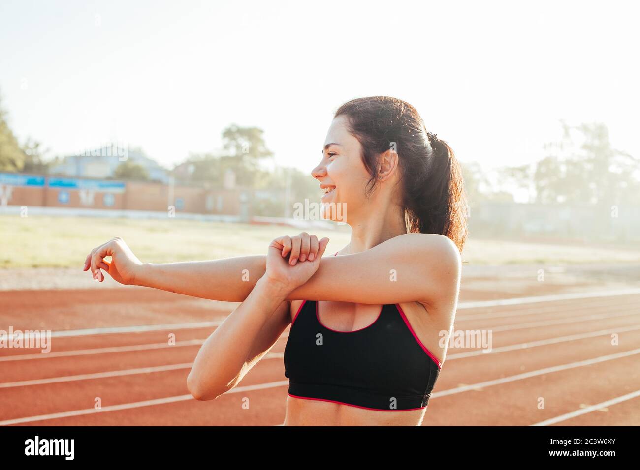 Femme athlétique qui s'étire sur la piste de course avant l'entraînement, santé physique farce Banque D'Images