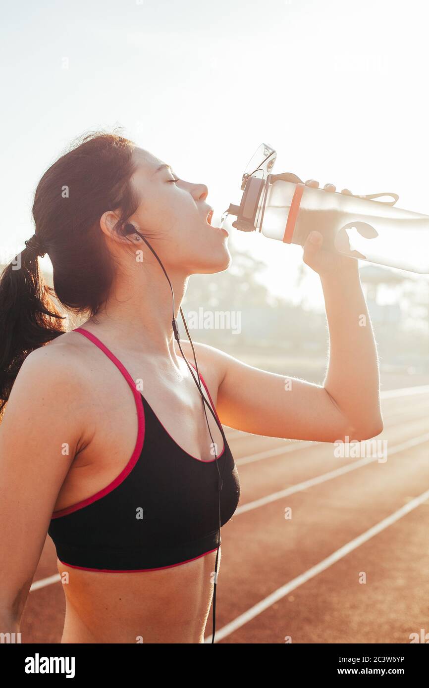 femme buvant une bouteille d'eau après avoir fait du jogging Banque D'Images