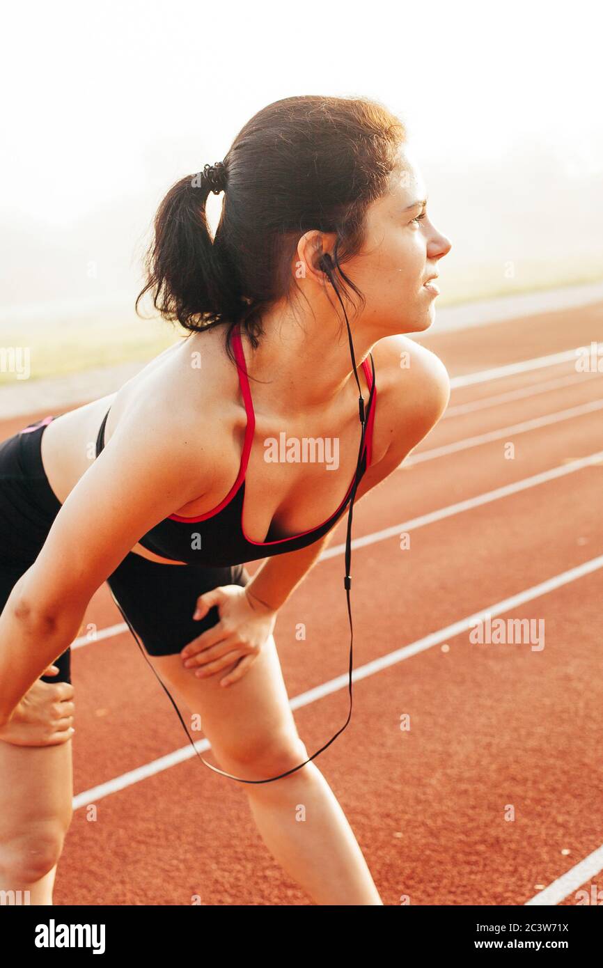 Femme sportive se préparant pour commencer sur la piste de course Banque D'Images