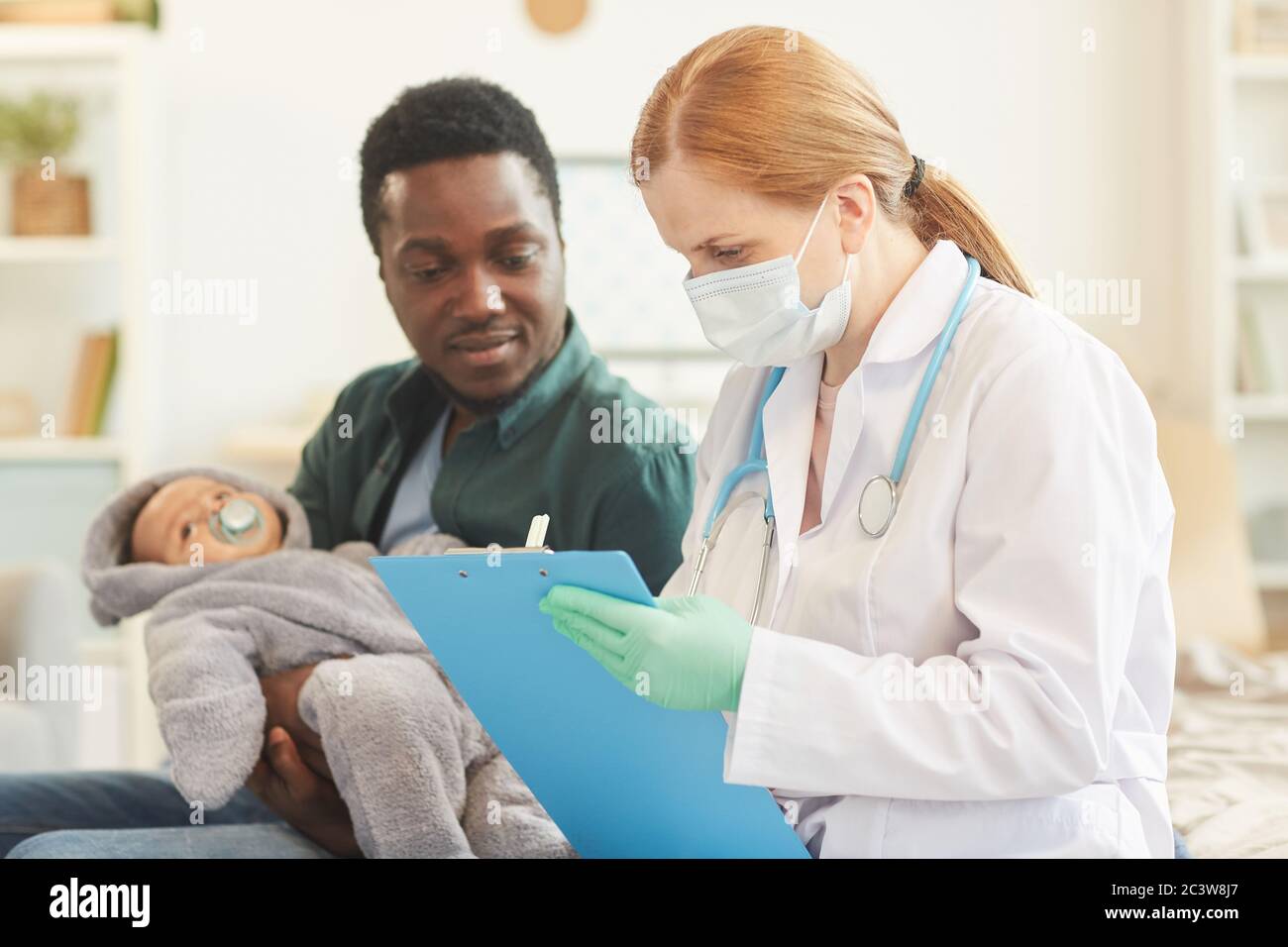 Portrait De La Femme Medecin En Vue Laterale Ecrit Sur Le Presse Papiers Lors De La Visite A Domicile Pour L Examen De Bebe Espace De Copie Photo Stock Alamy