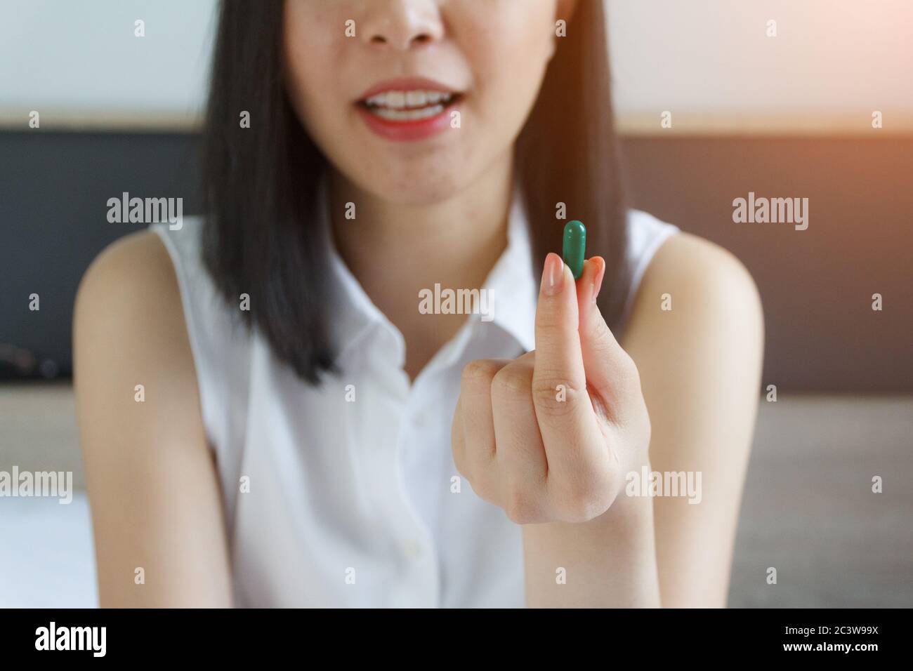 jeune femme prenant la pilule, prenant des drogues. Médicaments au travail Banque D'Images