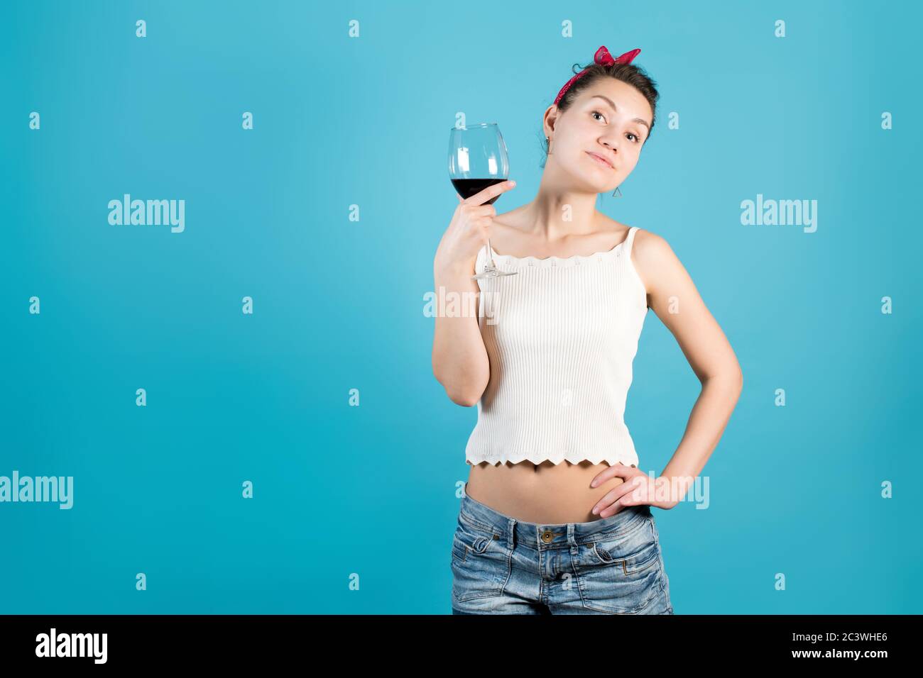 Fille posant avec un verre de vin rouge Banque D'Images