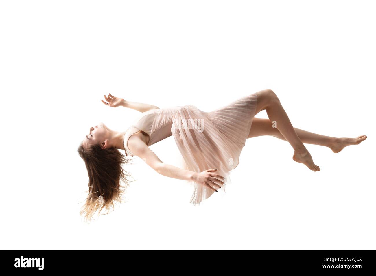 La beauté en plein air est un moment. Photo en longueur d'une jeune femme attirante planant dans l'air et gardant les yeux fermés. Lévitant dans la chute libre, le manque de gravité. Liberté, émotions, concept d'art. Banque D'Images