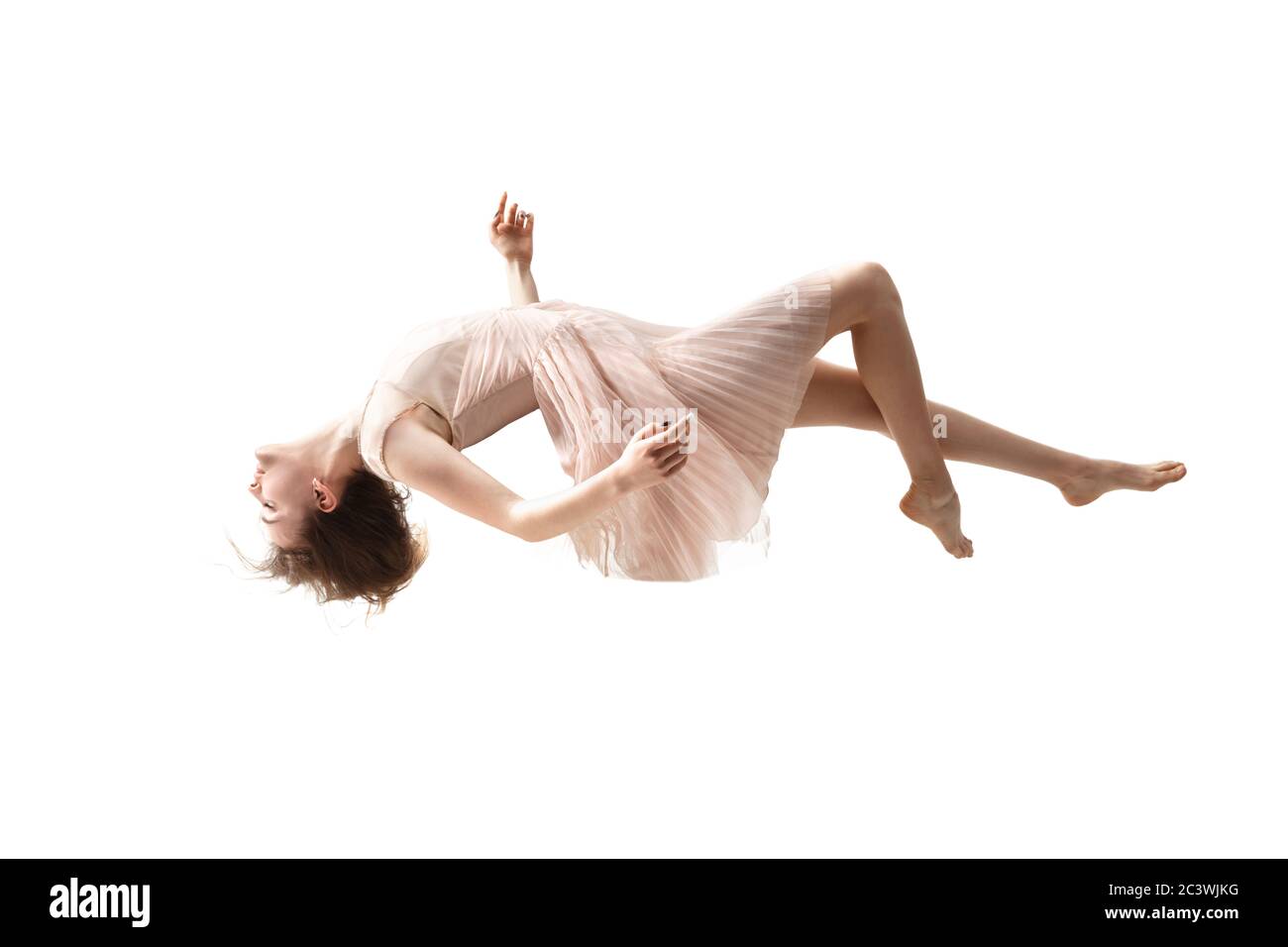 La beauté en plein air est un moment. Photo en longueur d'une jeune femme attirante planant dans l'air et gardant les yeux fermés. Lévitant dans la chute libre, le manque de gravité. Liberté, émotions, concept d'art. Banque D'Images