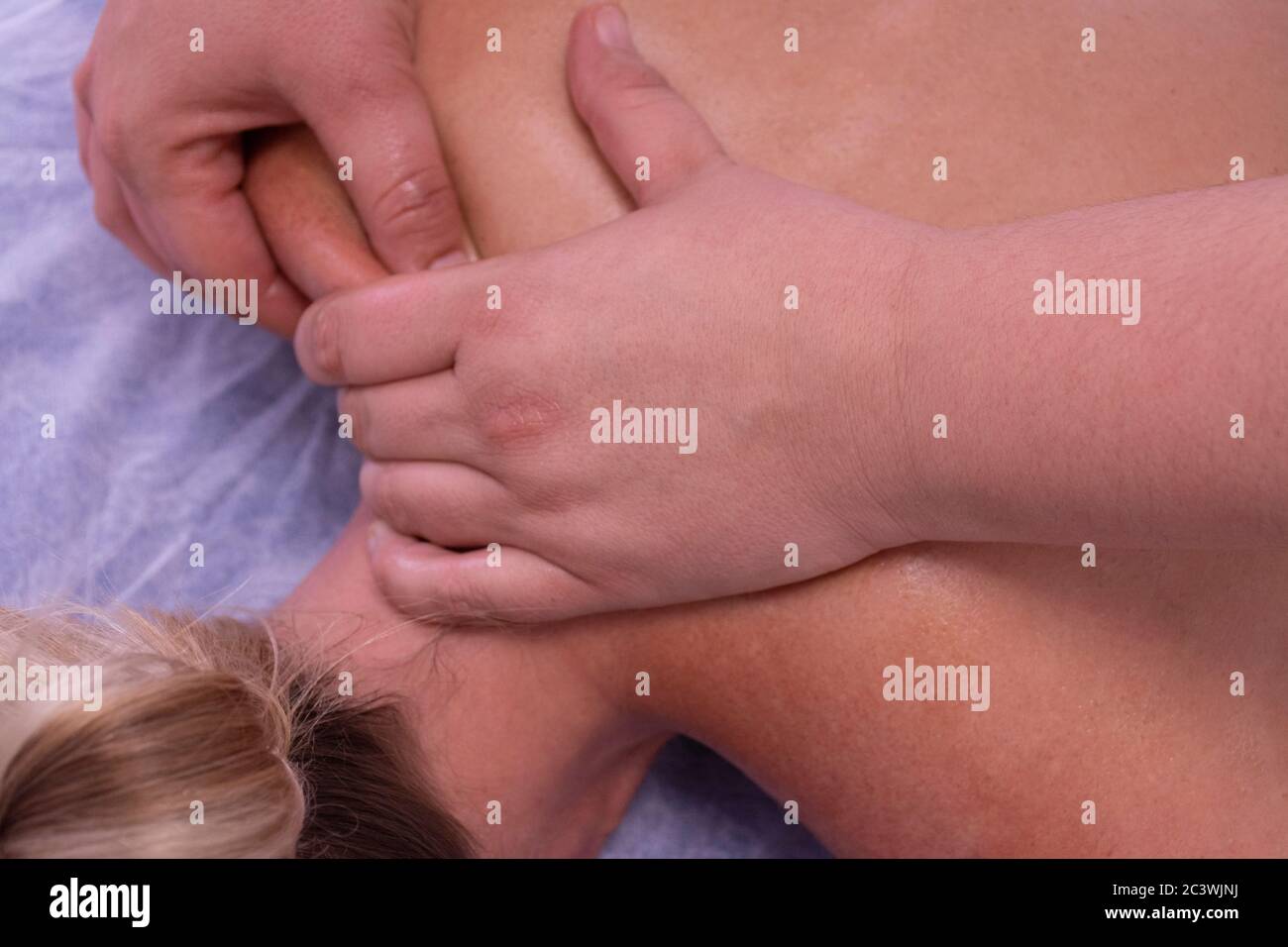 Les mains d'une femme méconnaissable fait un massage thérapeutique physiologique sur l'épaule d'une femme Banque D'Images