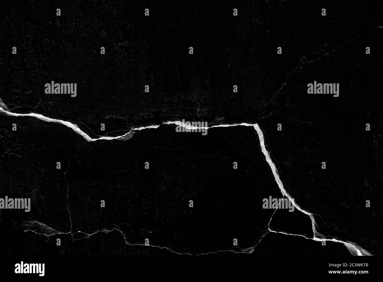 Mur noir fissuré avec une grande fissure, un fond ou une texture Banque D'Images